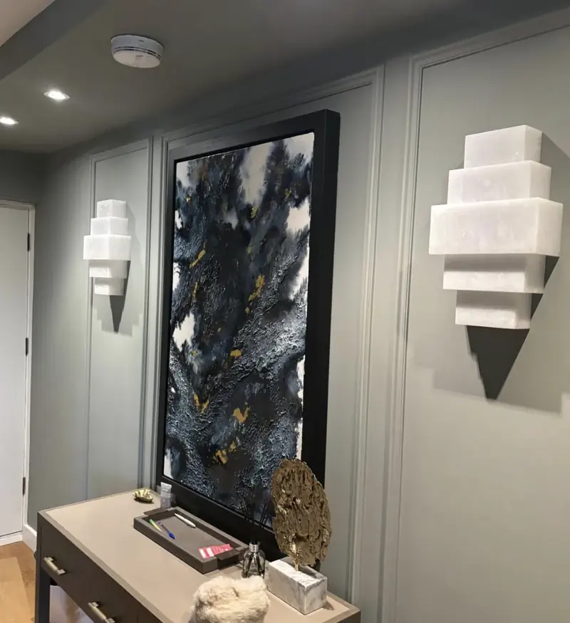 Hallway with panelled walls and brass wall lights