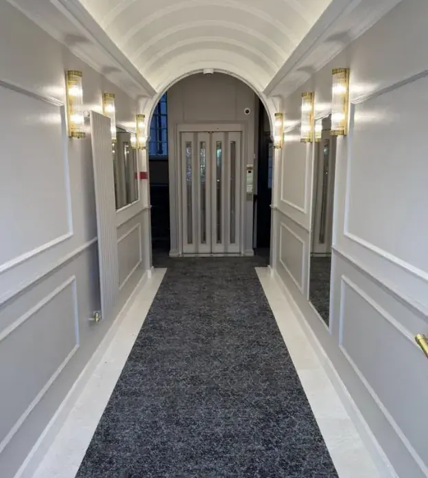 Entrance lobby, panelled walls and grey carpet runner